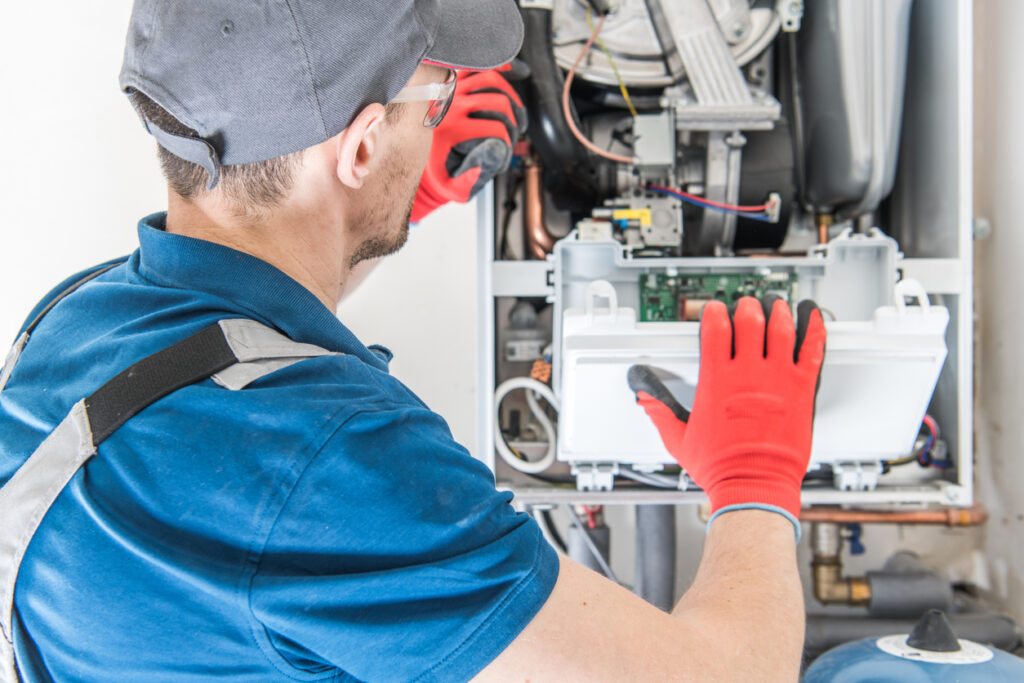 HVAC technician replacing the face of a newly installed residential furnace