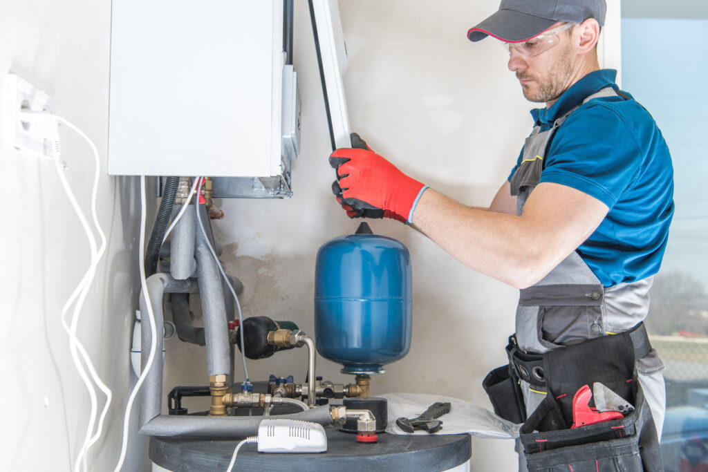 HVAC technician installing furnace in home.