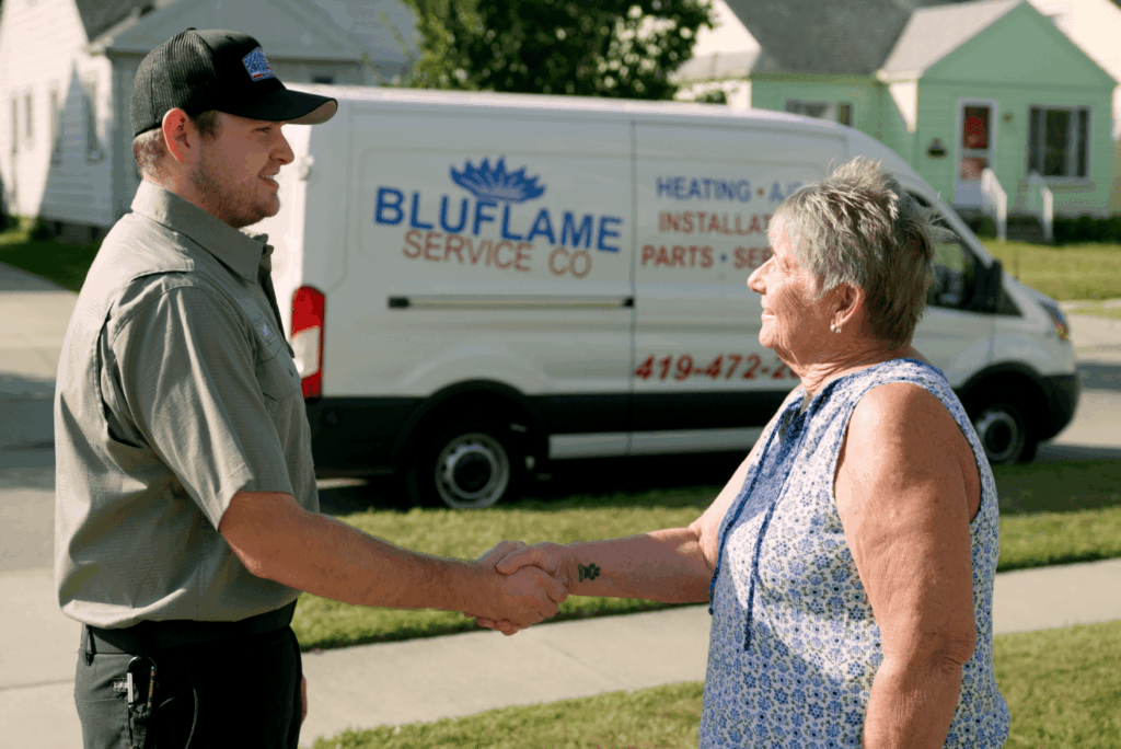 technican and customer shaking hands in front of van